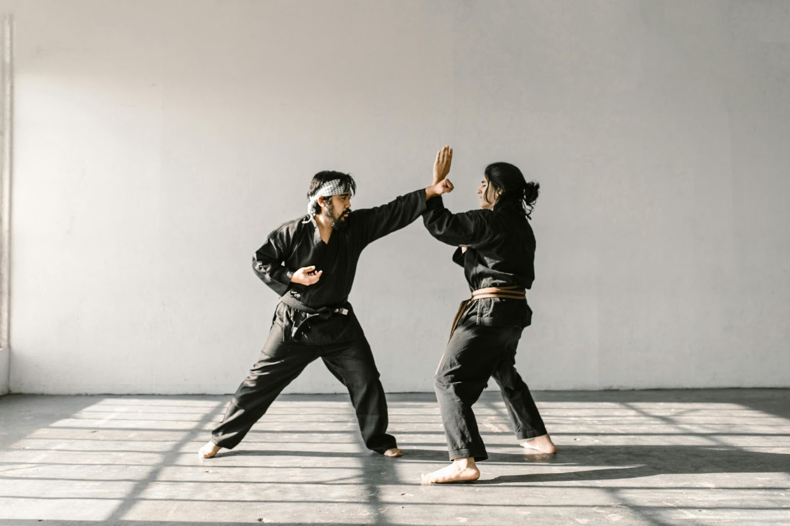 A female martial arts student training with her instructor