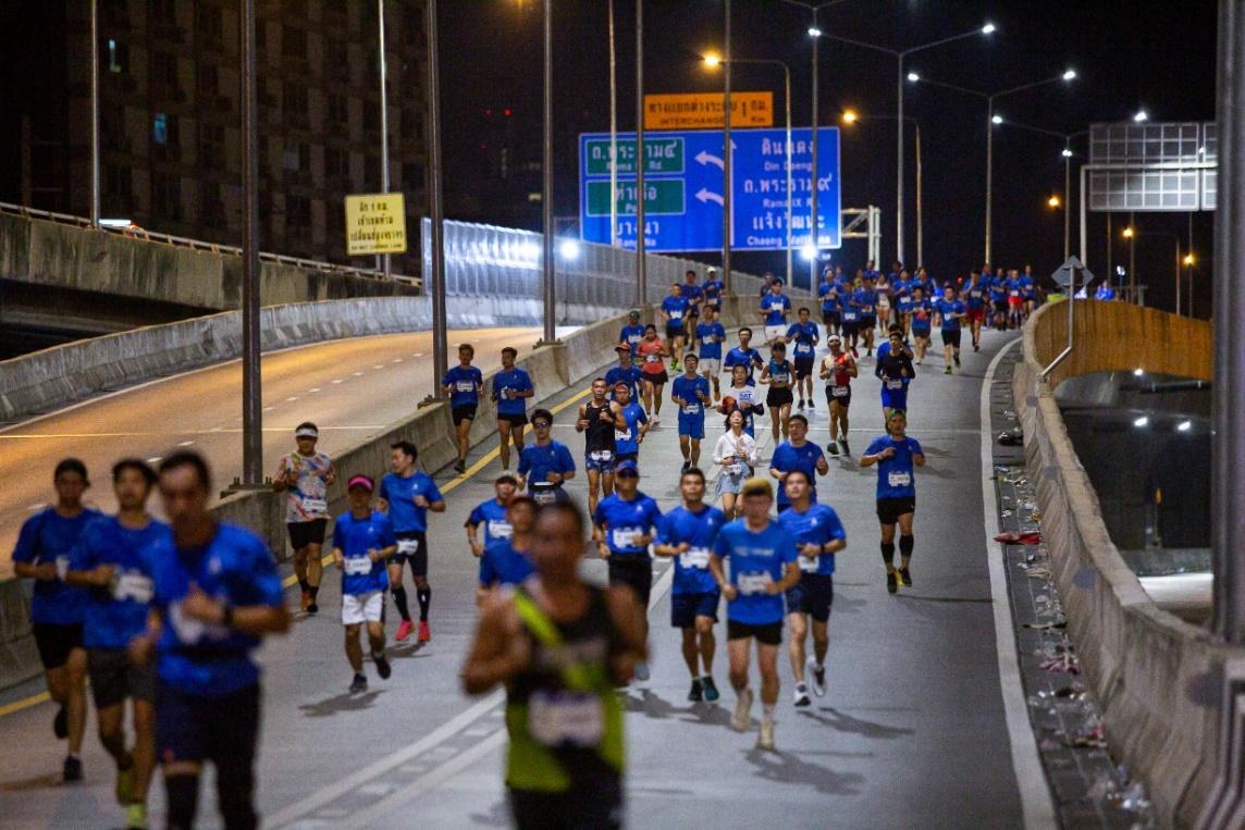 A group of people running on a road

Description automatically generated