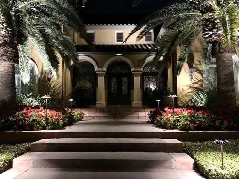 Path lights illuminating walkway to a home.