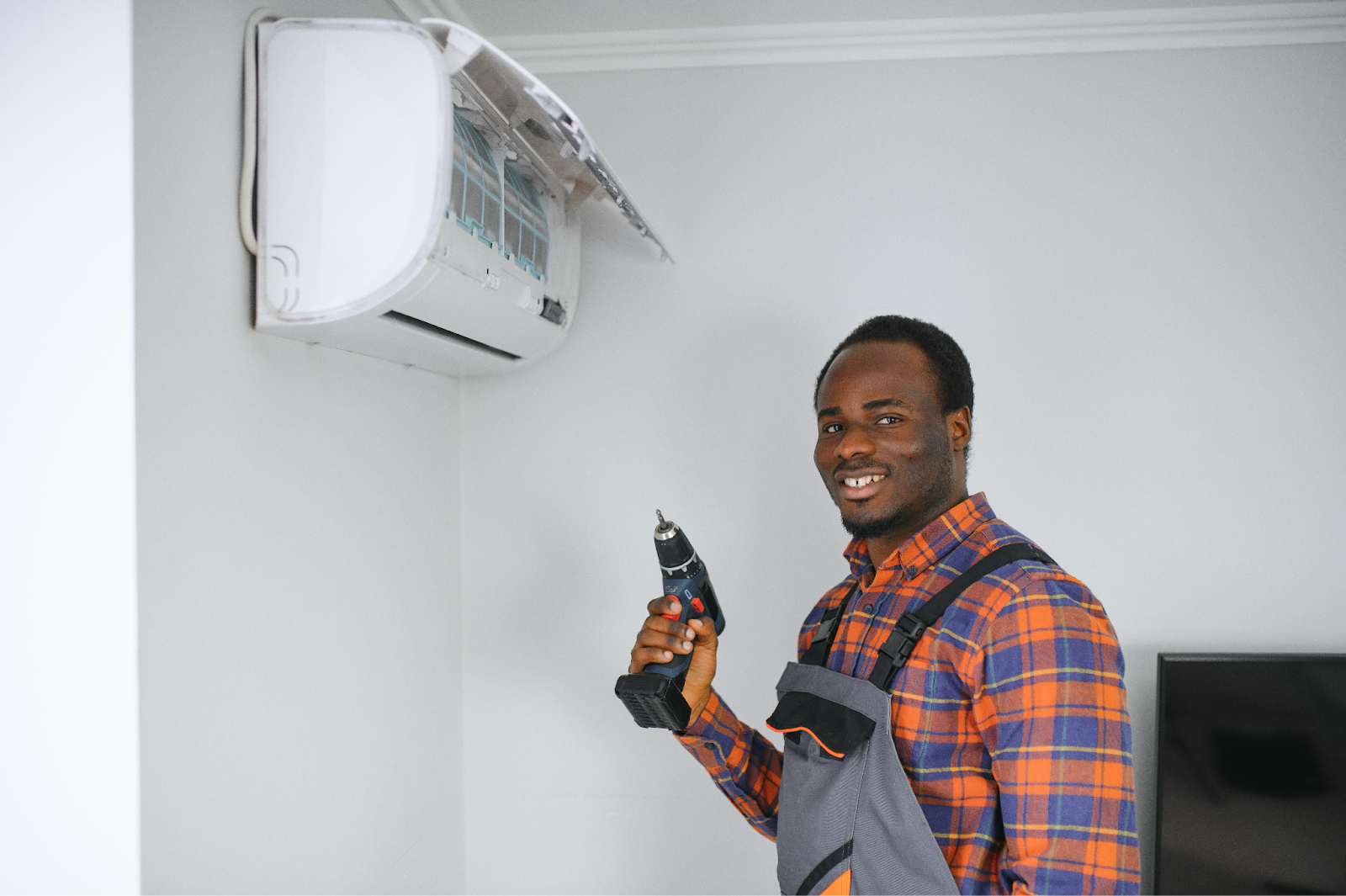 A repairman is preparing to fix an AC unit.