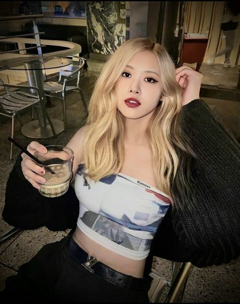 This  contain an image  BLACKPINK Rosé sitting at a table with a drink in her hand