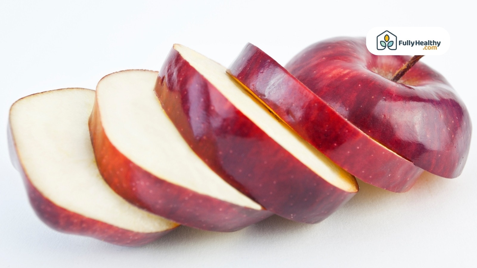 Sliced red apple arranged on a white background