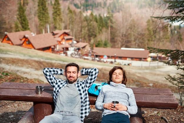 Smiling father and son with closed eyes relaxing outdoors