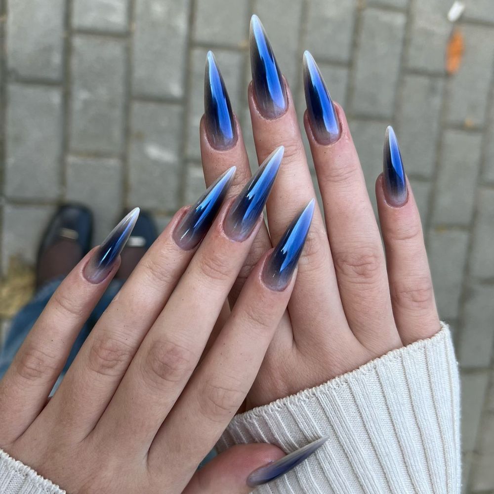 Close up of hands with blue winter nails having Stiletto Nail art for Cold weather