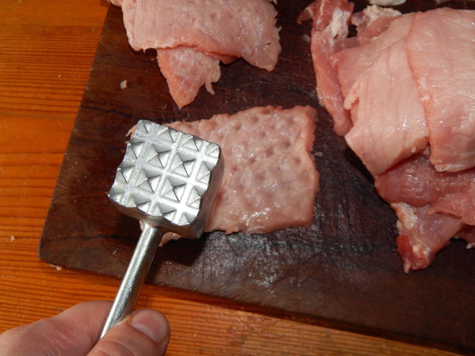 flattening raw veal cutlets with mallet