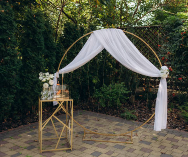 Contemporary stage decor featuring gold geometric frames intertwined with fresh flowers, blending modern style with floral elegance.