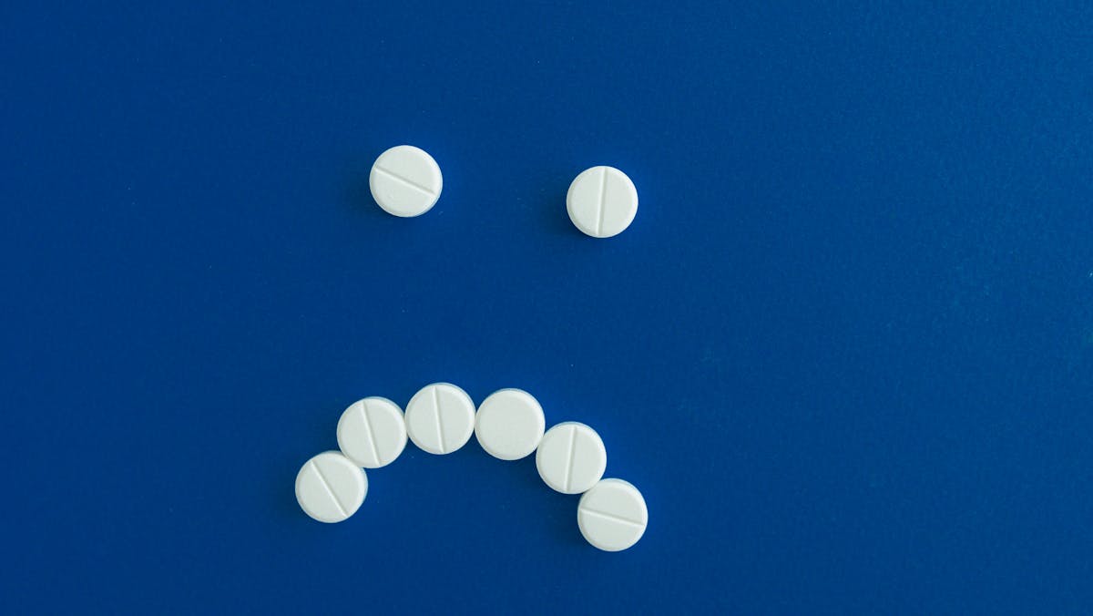 medicine tablets forming sad face