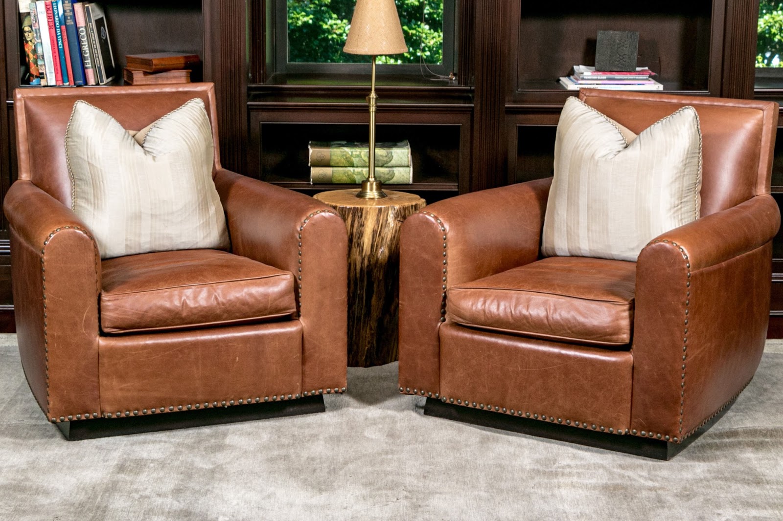 A pair of chocolate leather club chairs by Ralph Lauren in a moody library study.