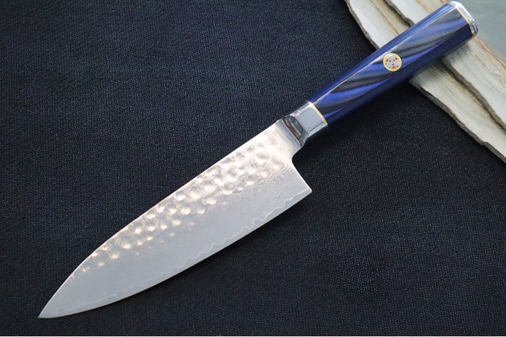 An image showing the Cangshan KITA Series six-inch chef knife on a solid black and wooden background.