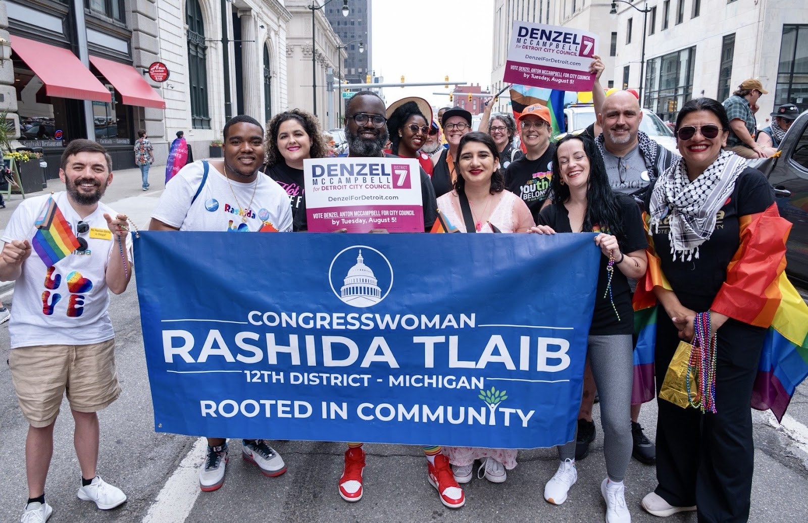 Rashida, Denz, and volunteers march in a pride parade.