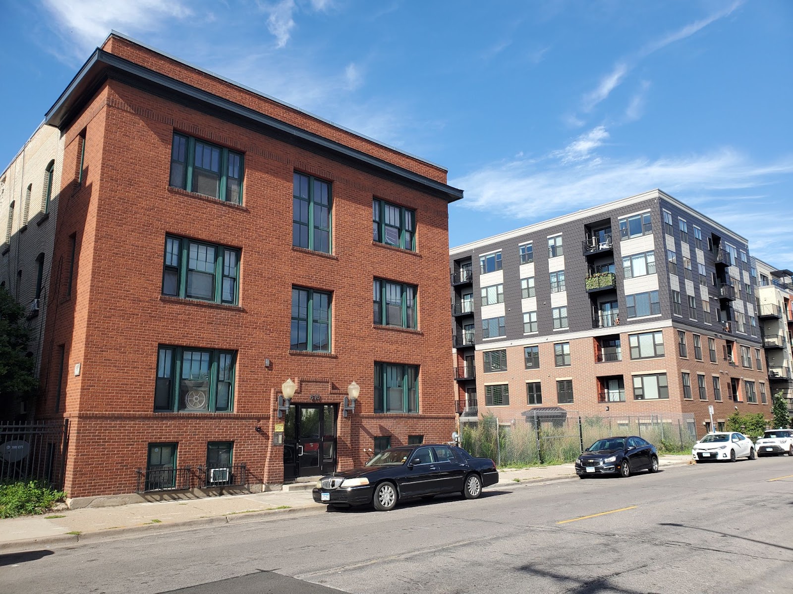 A streetscape with apartment buildings and a vacant lot in the Elliot Park neighborhood of MInneapolis.