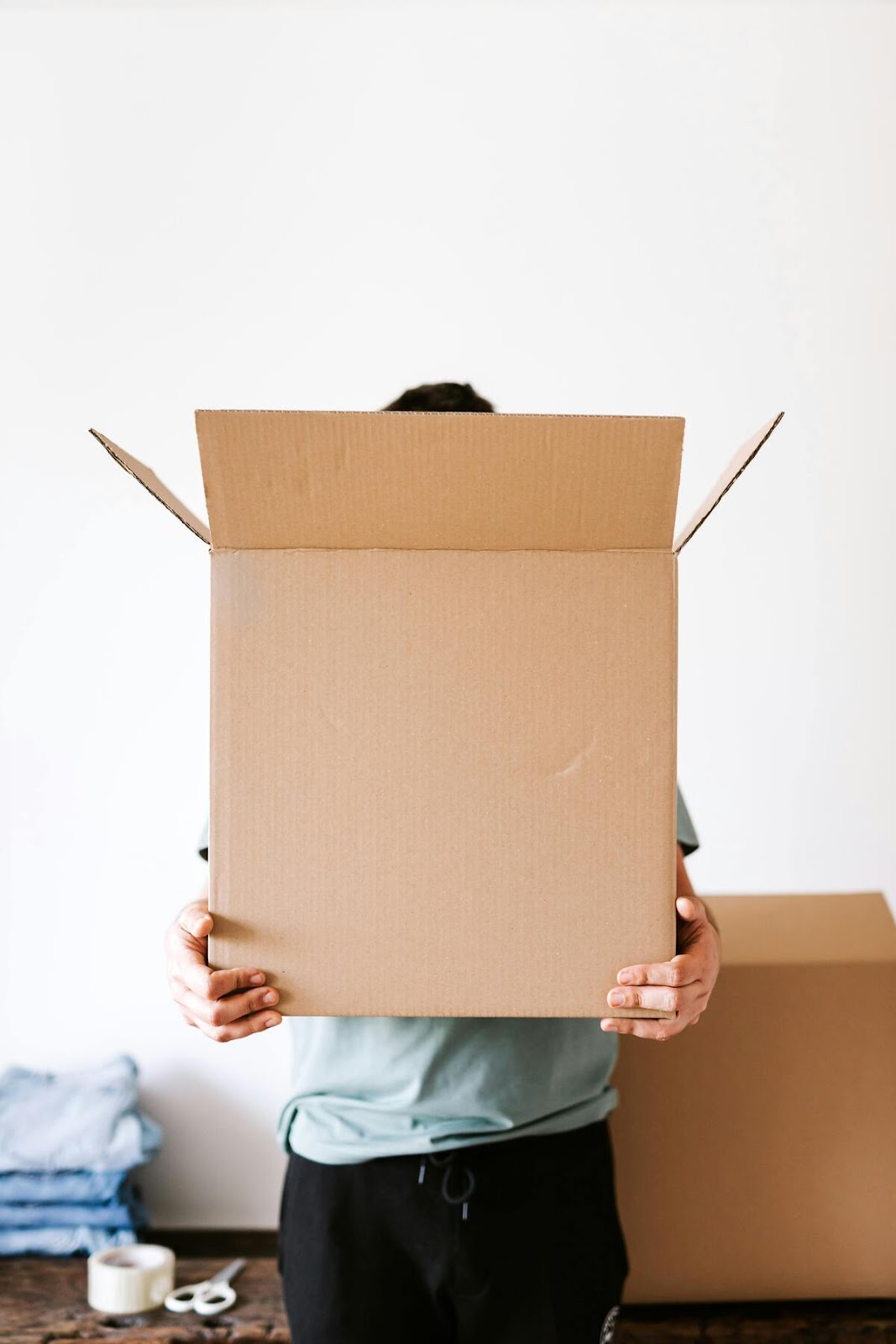 Man presenting a large box ready for shipment, ideal for sending bulk or high-volume orders efficiently