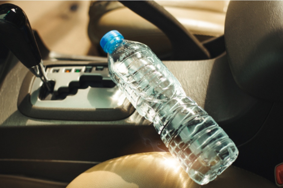 Warning about plastic water bottles in hot cars focusing sunlight and causing fires, with prevention tips and recommendations to use safer, reusable bottles.