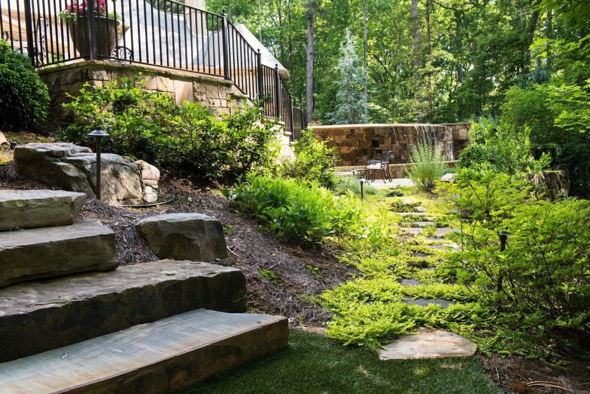 A backyard path benefitting from luxury home maintenance to help make it stay vibrant and beautiful.