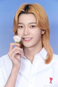 This contain an image of Sun Ying Hao putting on white shirt holding a flower