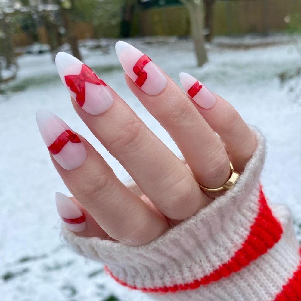 Close up of hands having Christmas red nails with Gift-Wrapped Red Nail Art