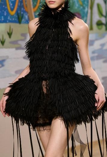 A person wearing a black feather dress

Description automatically generated