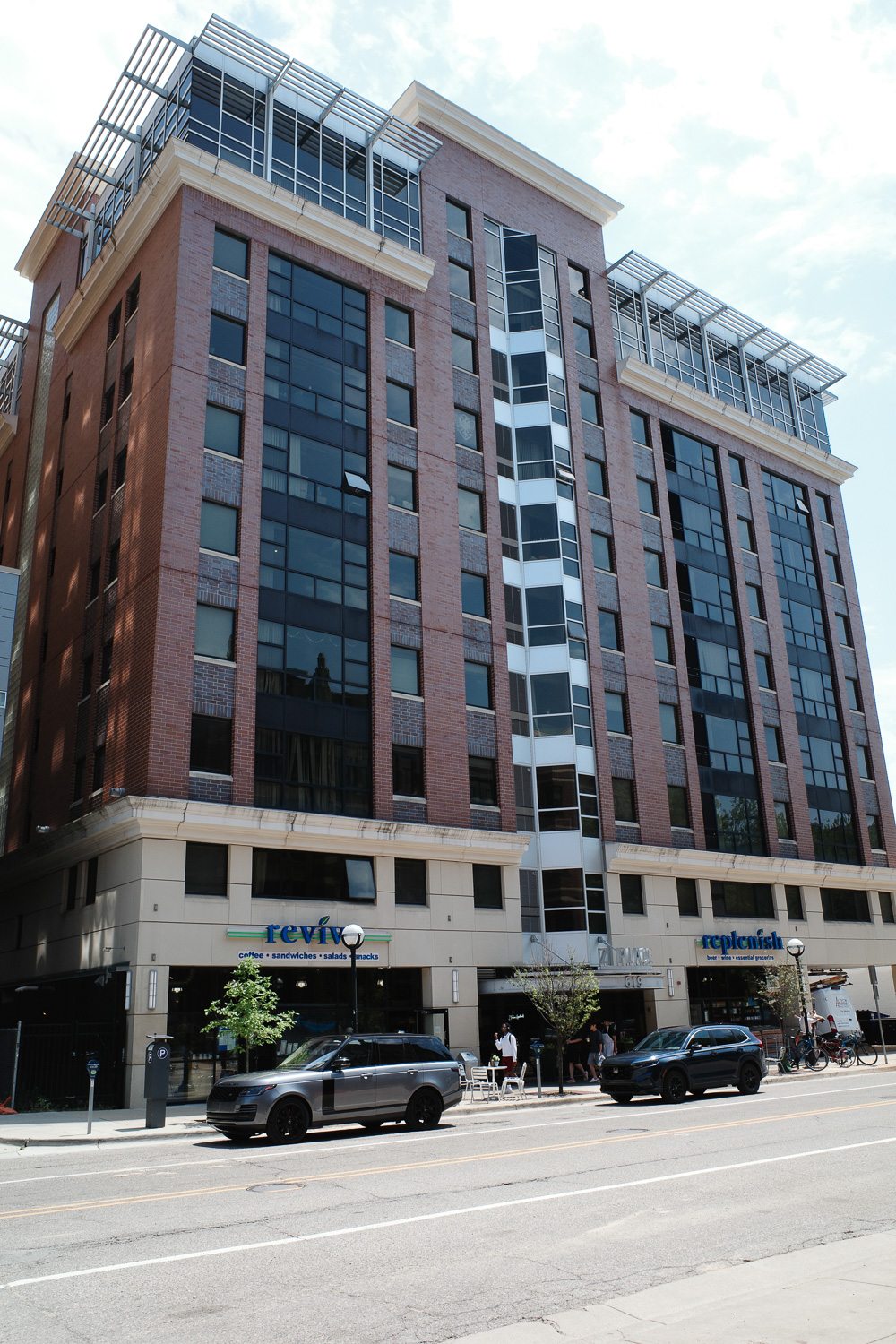 Zaragon apartment building in Ann Arbor with signs on ground floor reading "revive, coffee sandwiches salads snacks" and "replenish"