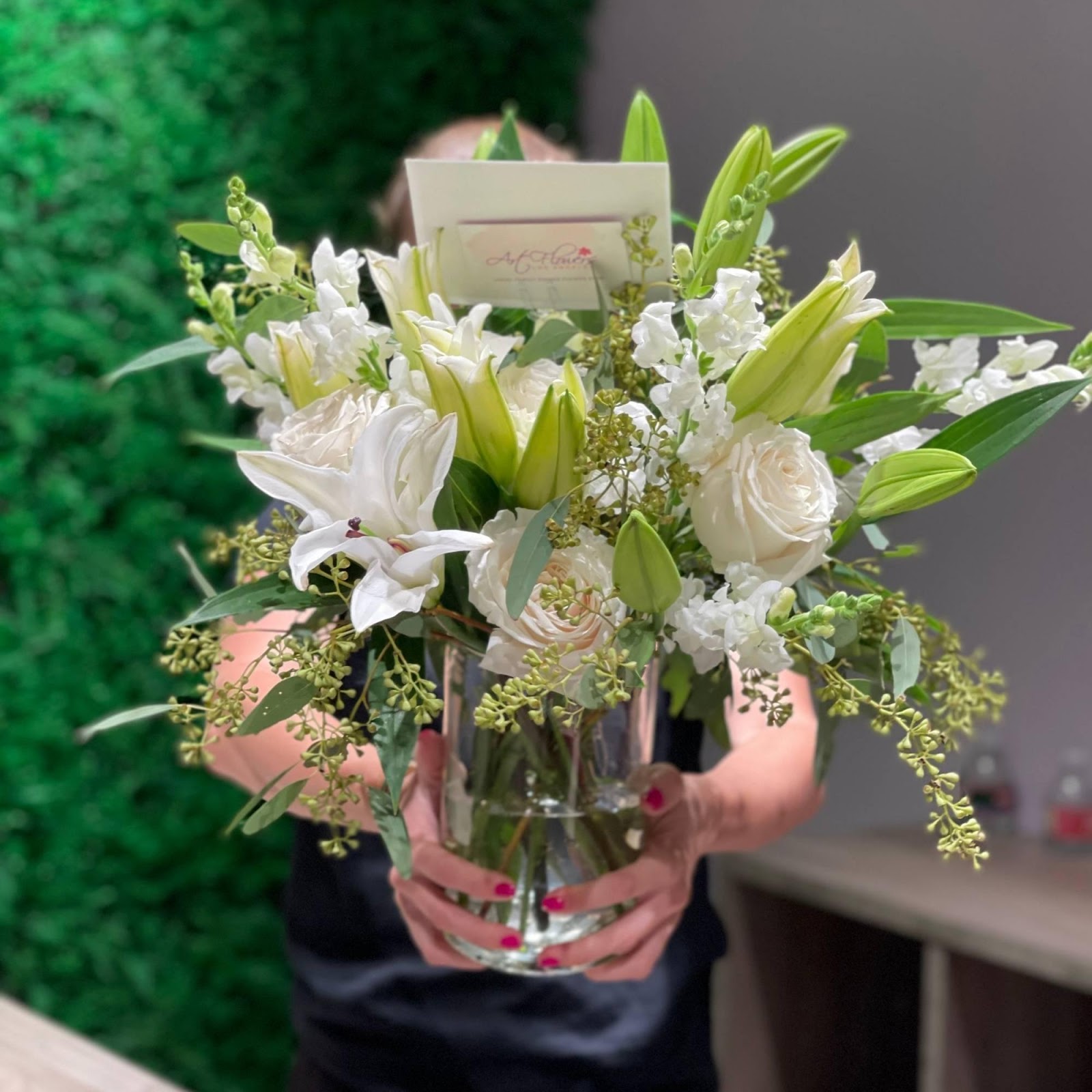 A beautifully arranged vase filled with vibrant roses, elegant lilies, fragrant matthiola, and lush eucalyptus, showcasing a stunning floral display.