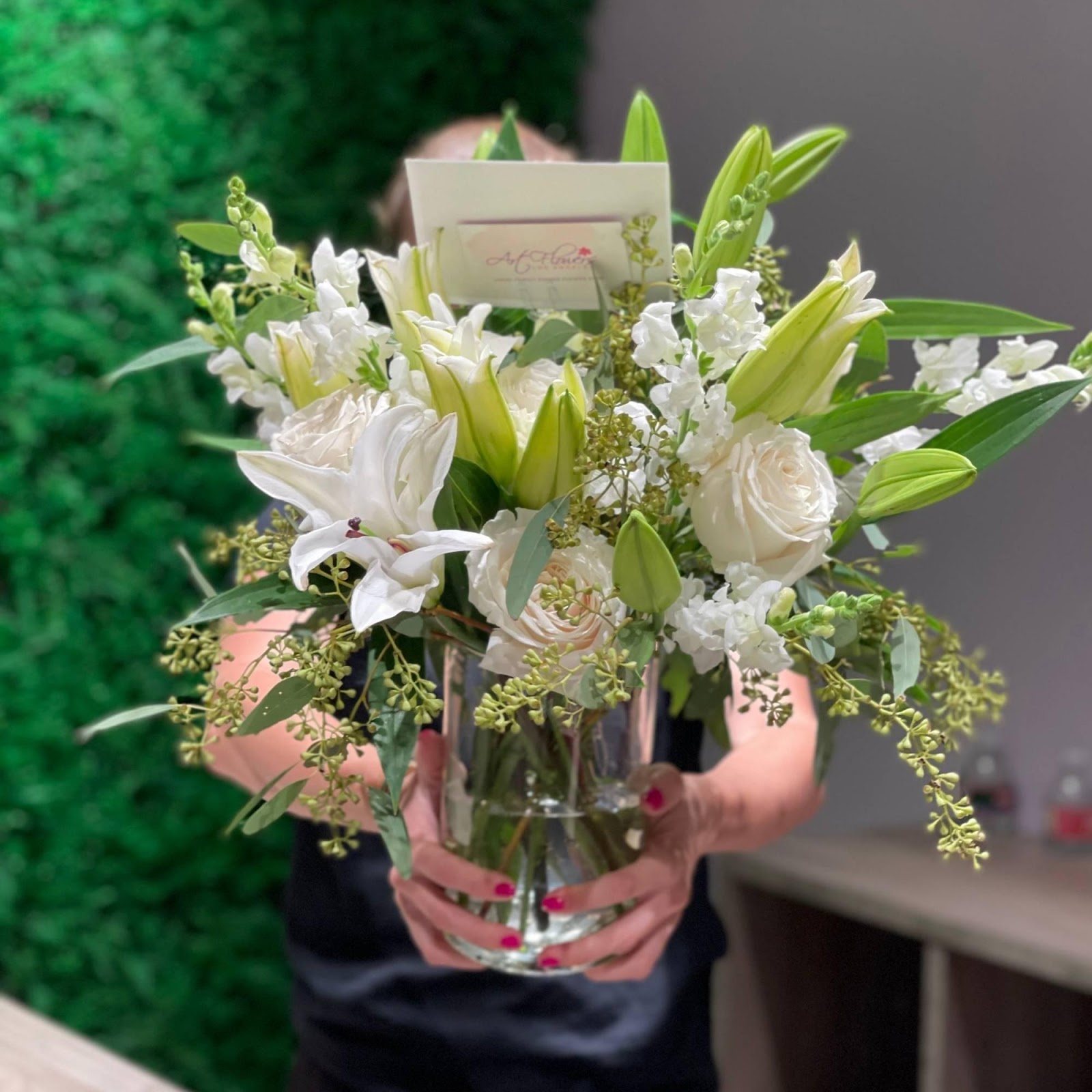 A beautifully arranged vase filled with vibrant roses, elegant lilies, fragrant matthiola, and lush eucalyptus, showcasing a stunning floral display.