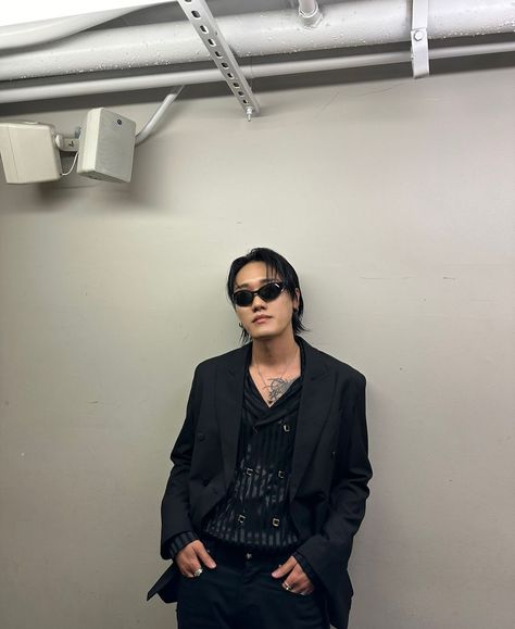 This contain DPR Artic wearing sunglasses standing in front of a wall with his hands in his pockets