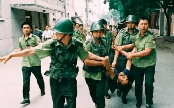 This contains an image of policemen dragging  Lao Rongzh 