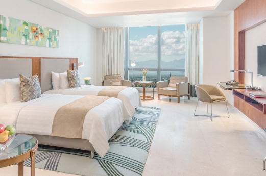 A room with two beds and a table and chairs

AI-generated content may be incorrect.