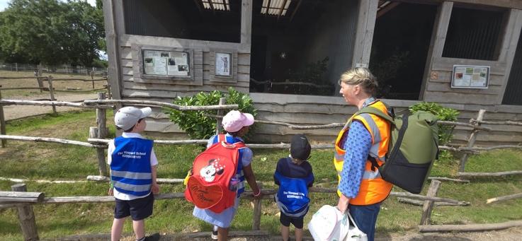 A group of children standing next to a building

Description automatically generated