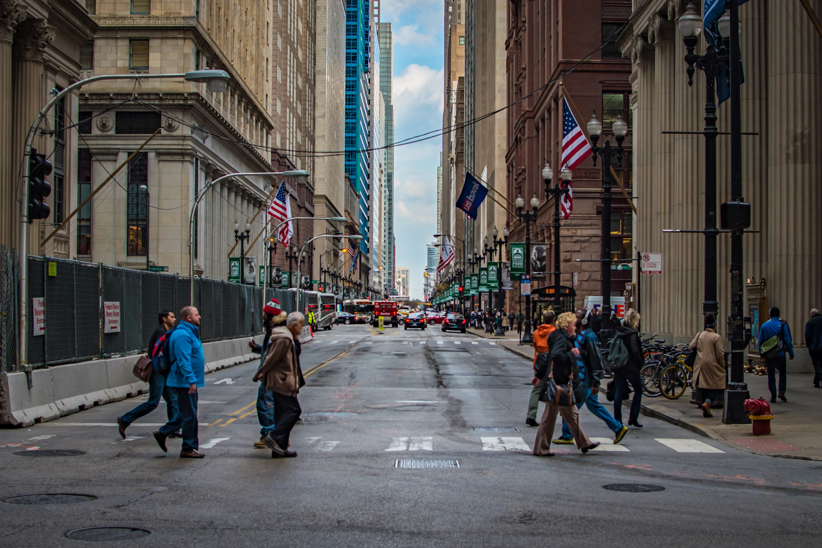 Photo of people walking across a sidewalk in New York City. Image via Pexels