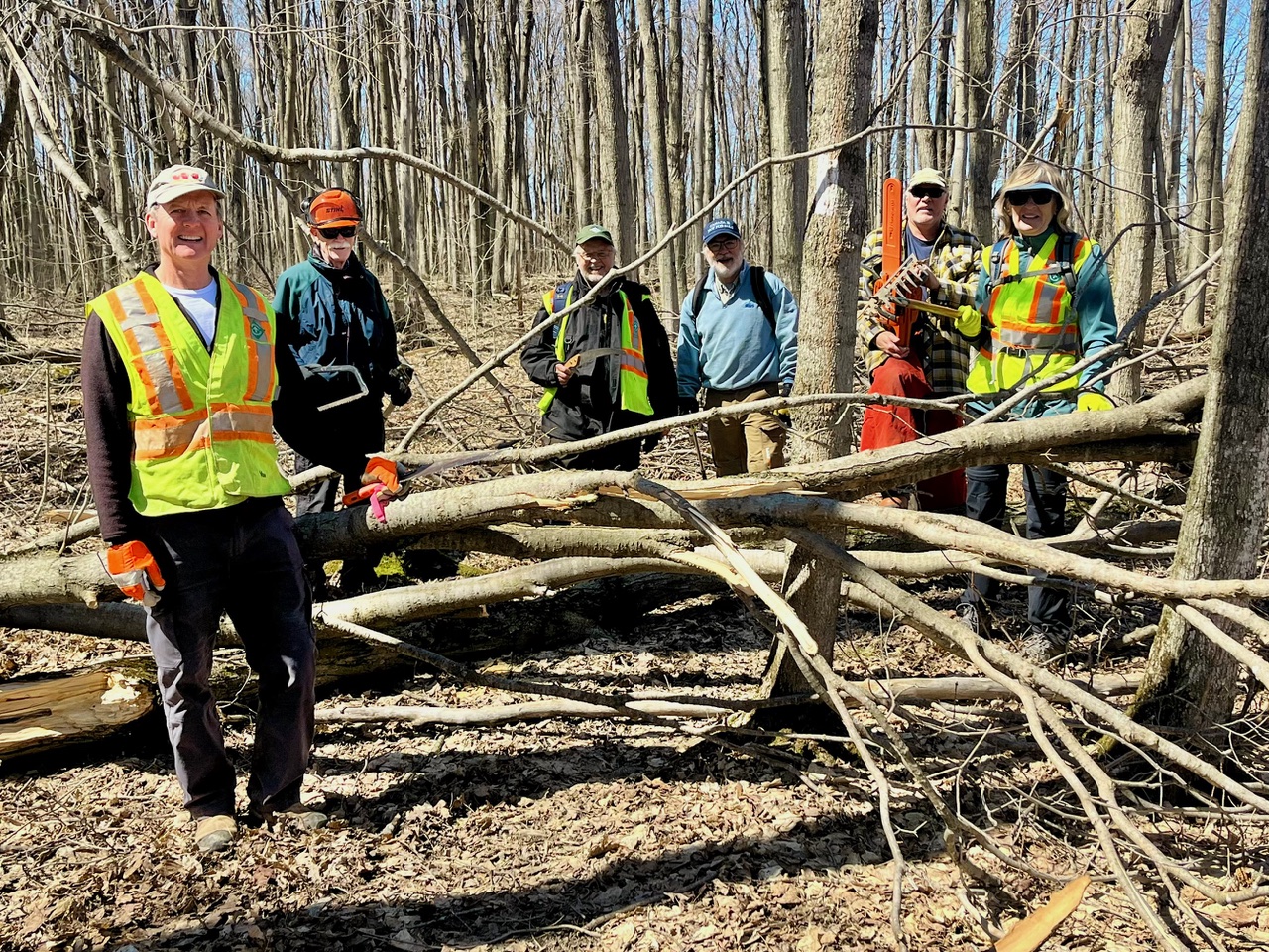 Six members of the Ice Storm Crew stand around a fallen tree.