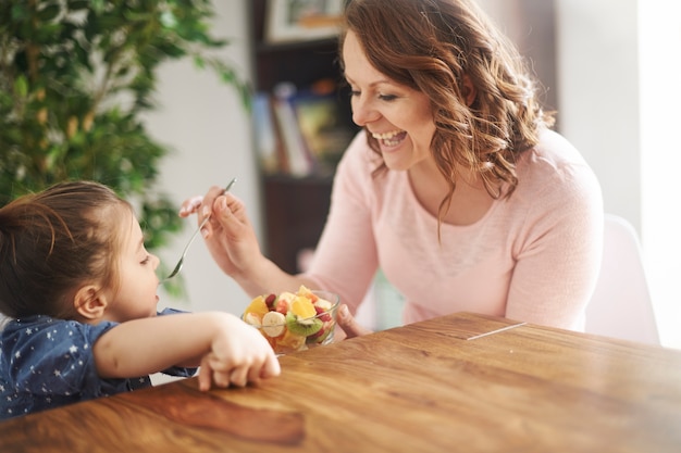 A mother offering food to her daughter