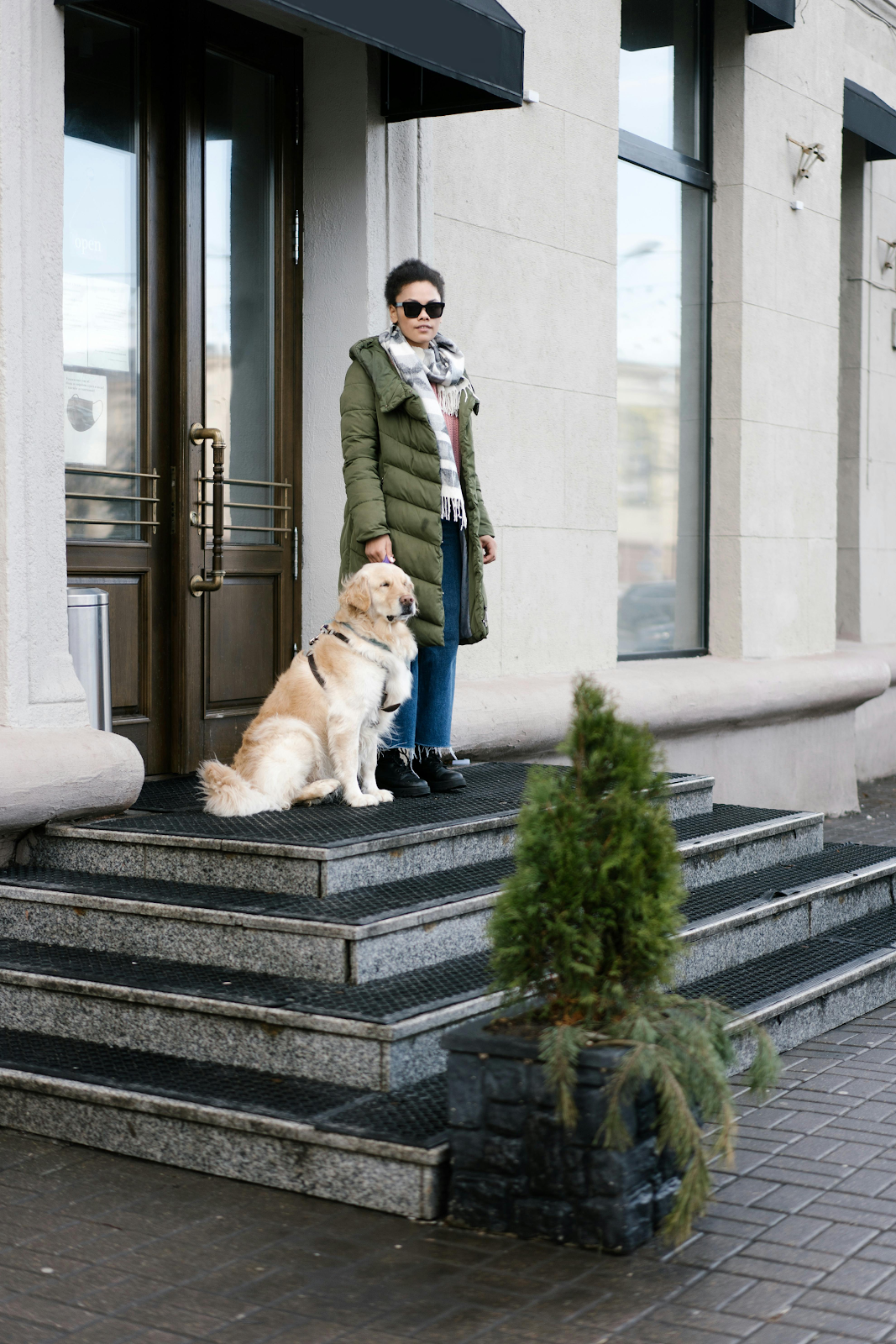 A person and a dog on the steps of a buildingDescription automatically generated