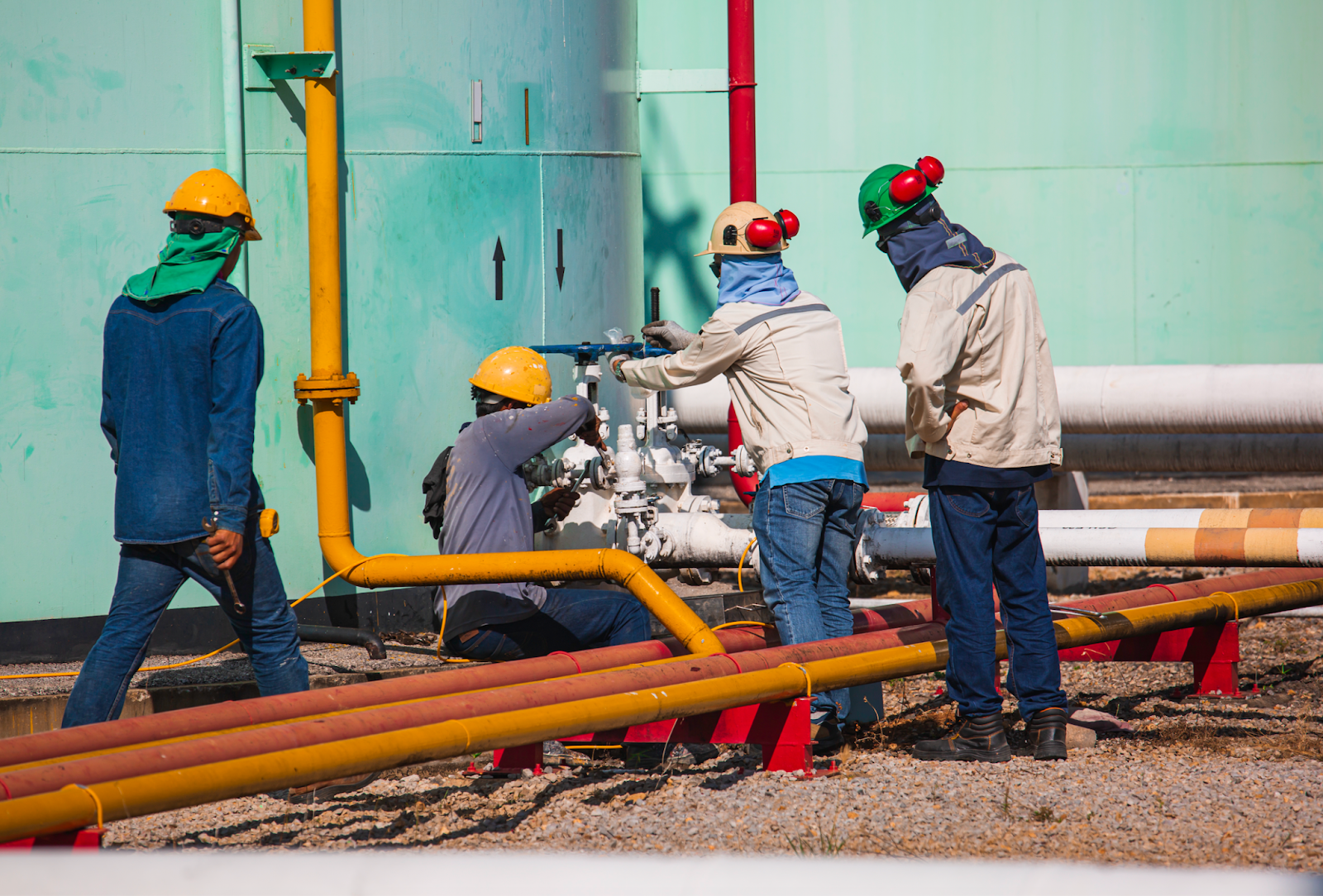 An image of four pipeline workers working on a pipeline.