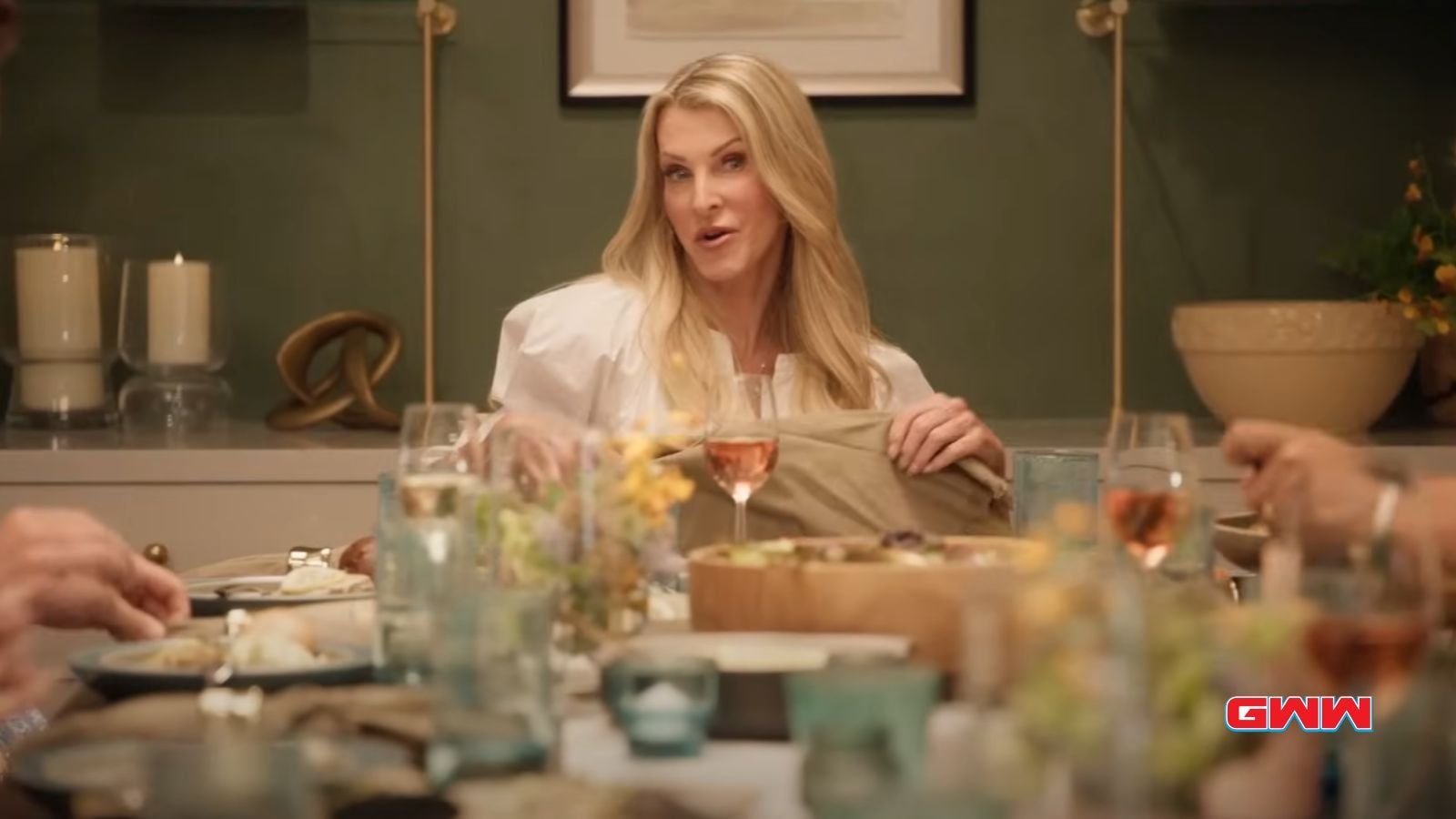 Joan holding a napkin and smiling while sitting at a dinner table.