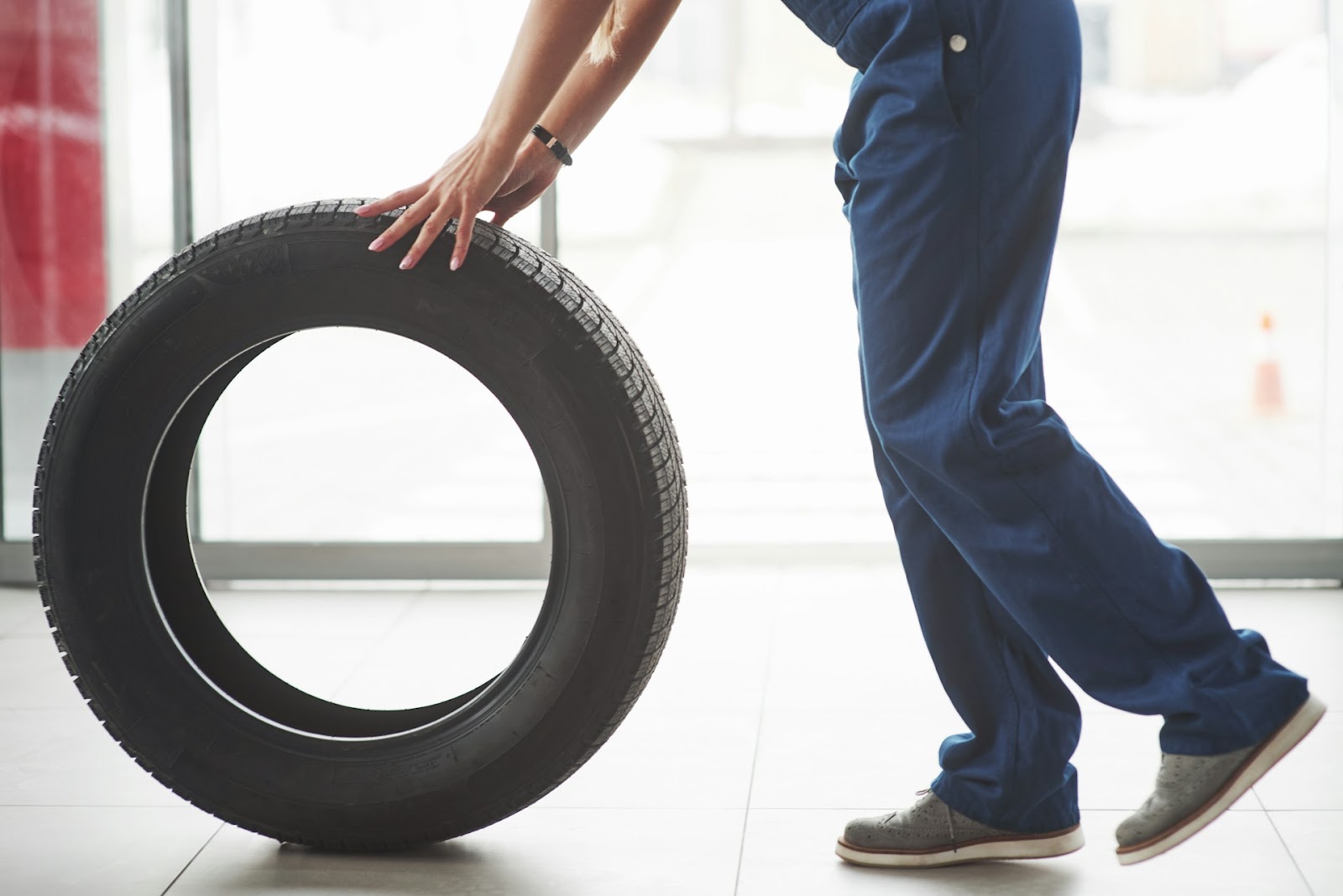 a mechanic holding a car tire