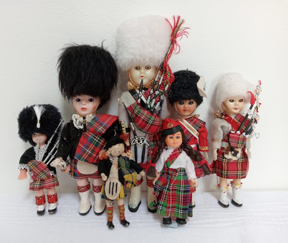 A large collection of Scottish dolls, many of them holding bagpipes