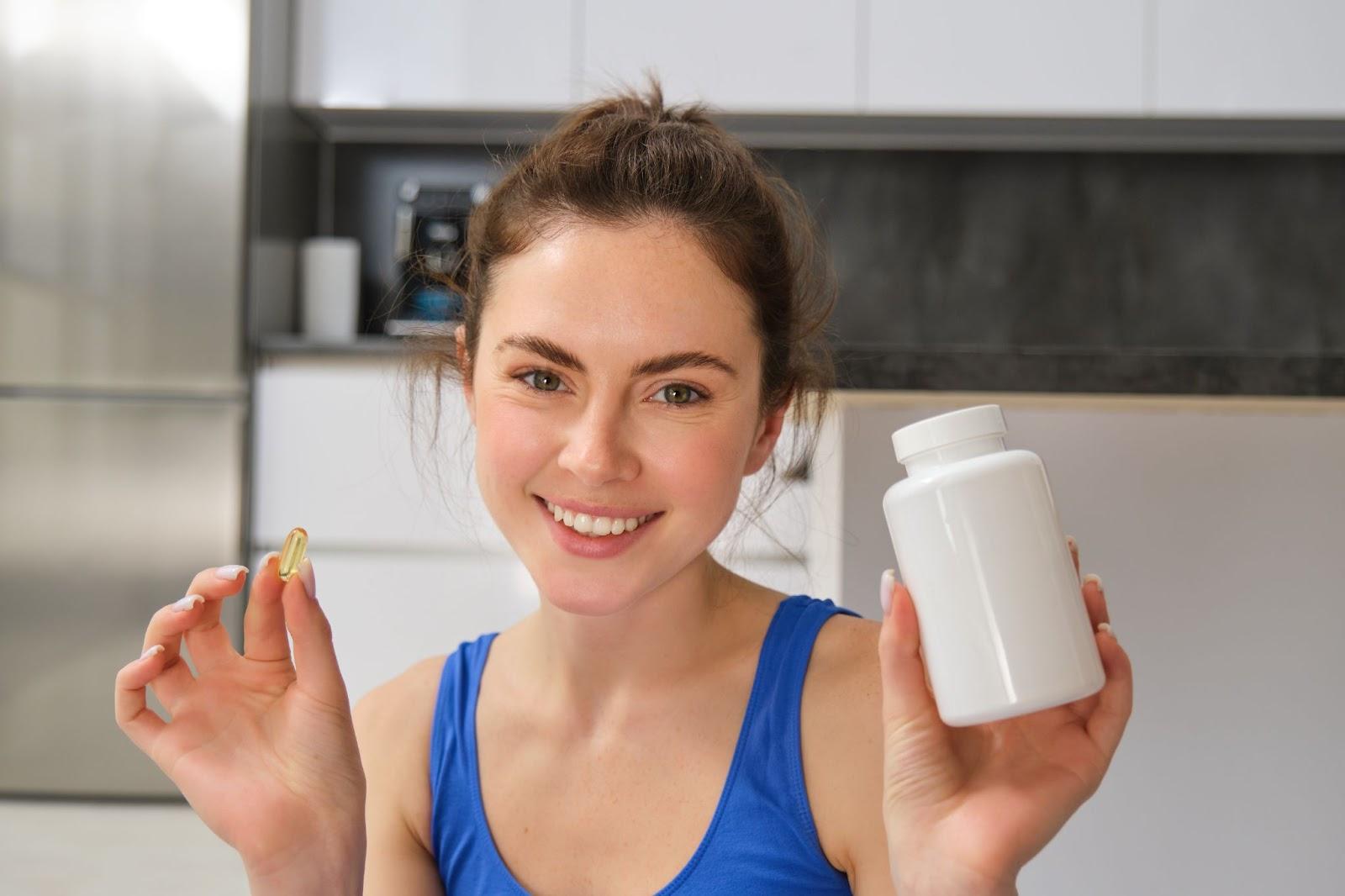 A person holding a pill and a bottle

AI-generated content may be incorrect.