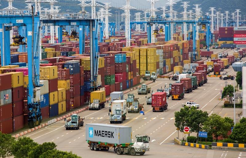 A large group of trucks in a port

Description automatically generated