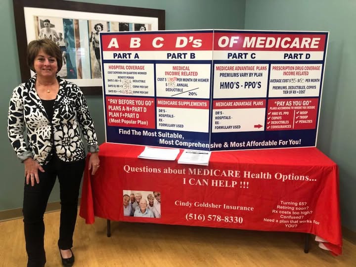 A woman smiling in front of a Medicare poster board explaining how memory care can be covered with Medicare