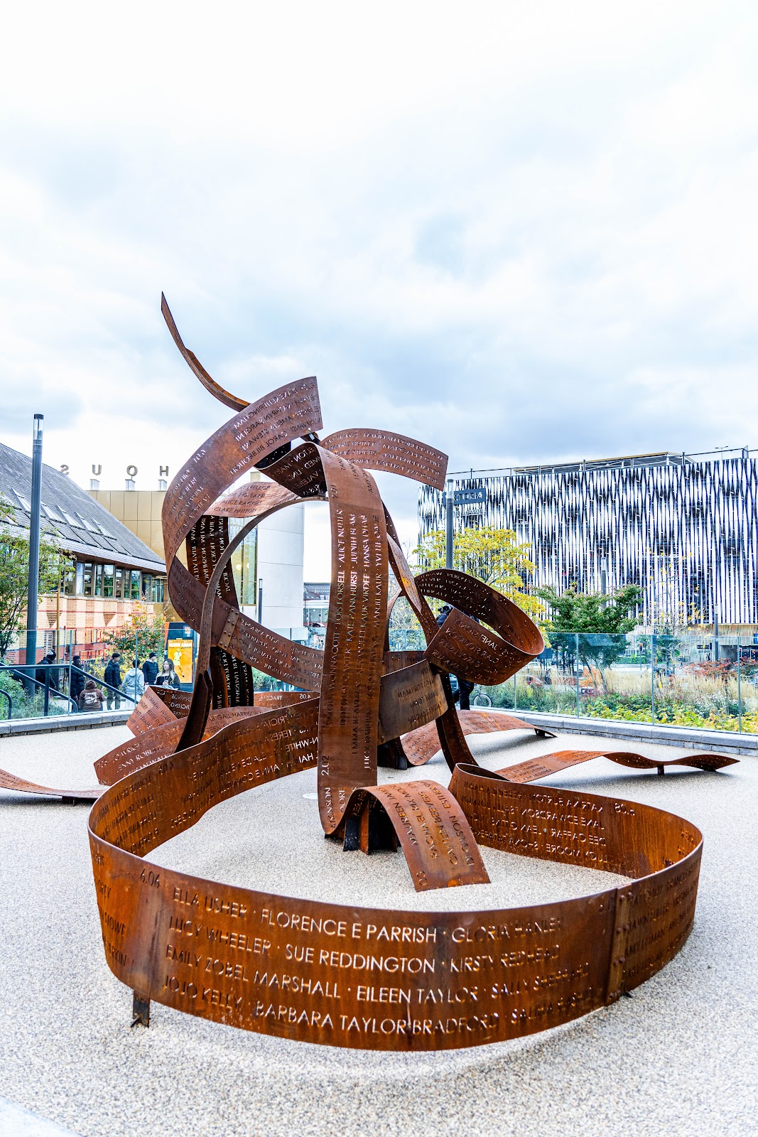 a large rust coloured sculpture of metal ribbons engraved with names