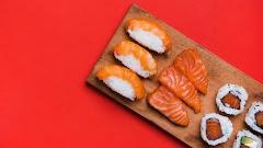 Sushi Roll With Salmon Chopping Board Against Red Background