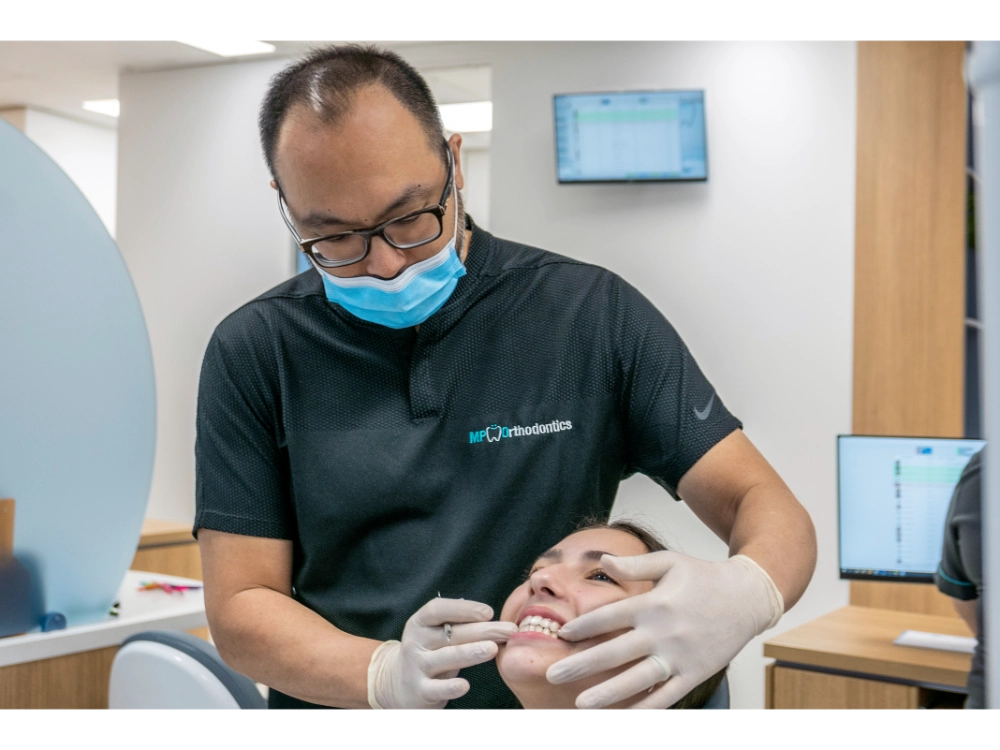 Orthodontist examining patient’s smile during Invisalign consult in clinic by MP Orthodontics