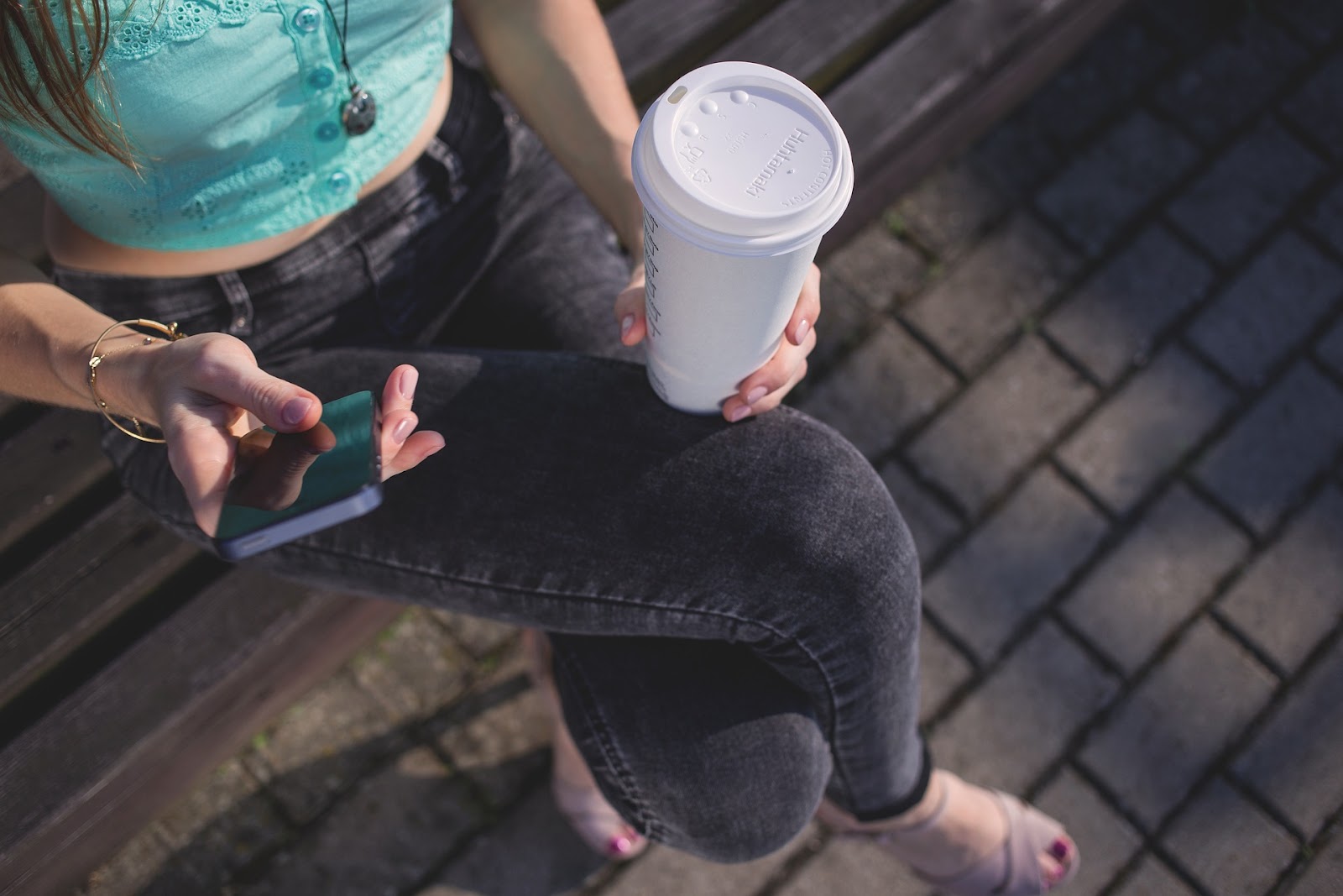 コーヒー　女性　スマホ　ベンチ