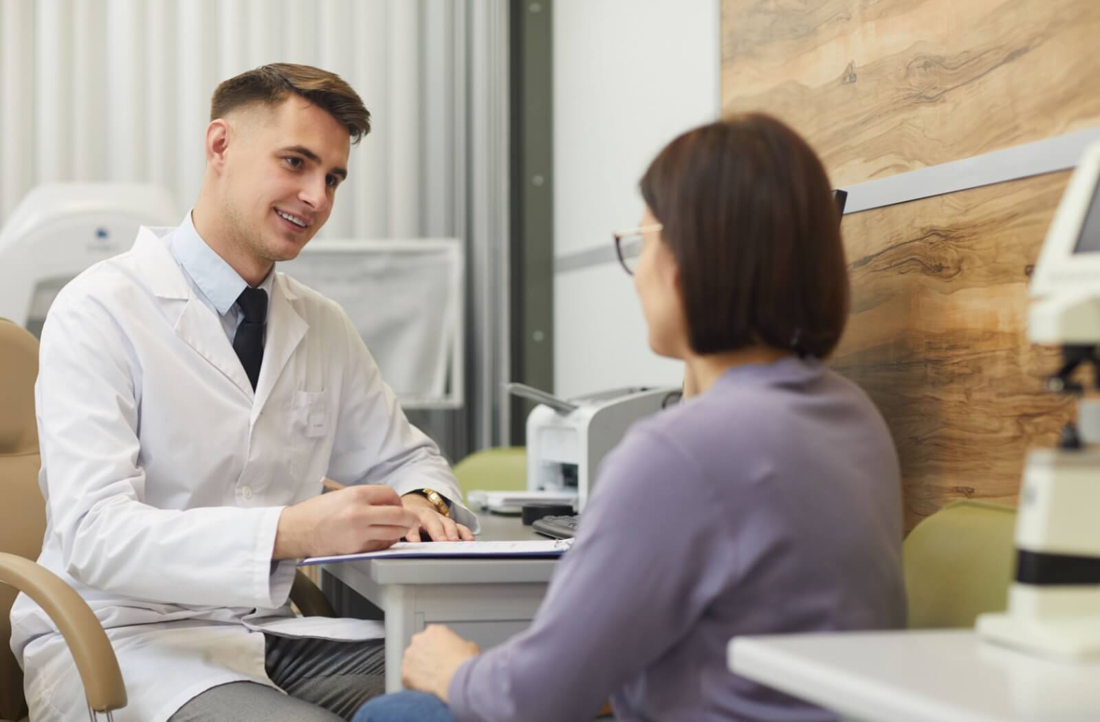 An optometrist discusses dry eye treatment with their patient.
