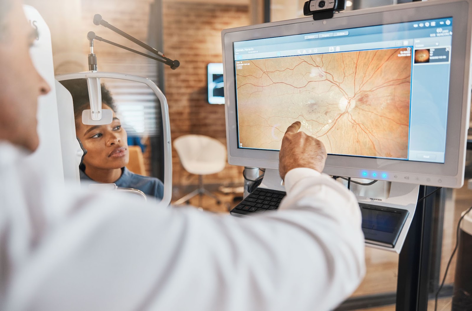 An optometrist reviews a tomography image with his patient.