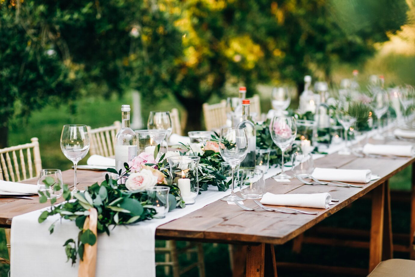 Olive green wedding decor ideas for the reception featuring greenery table settings, olive and gold place cards, hanging eucalyptus and olive leaf arrangements, and green velvet lounge decor for an earthy elegant wedding.