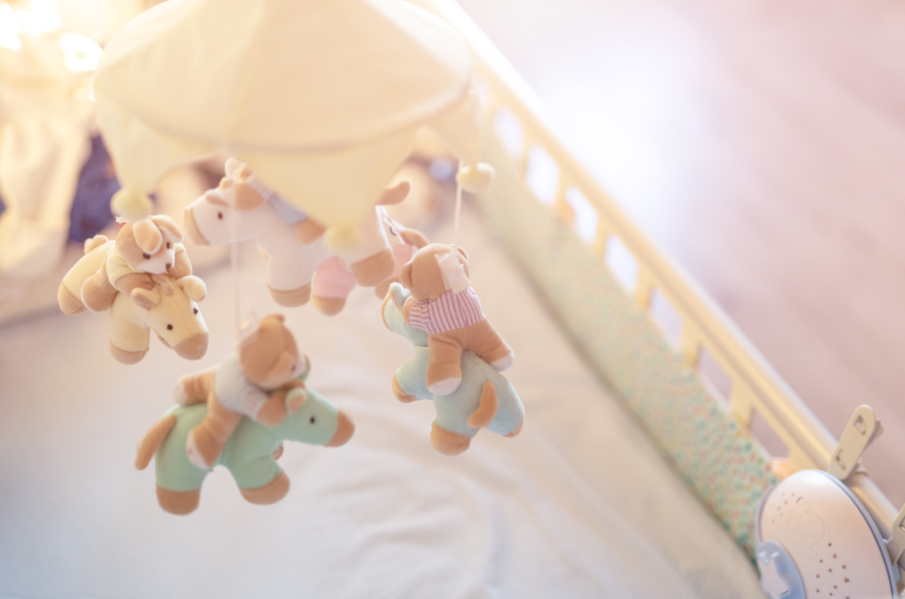 Up close of a crib with hanging toys // Healthier Baby Today