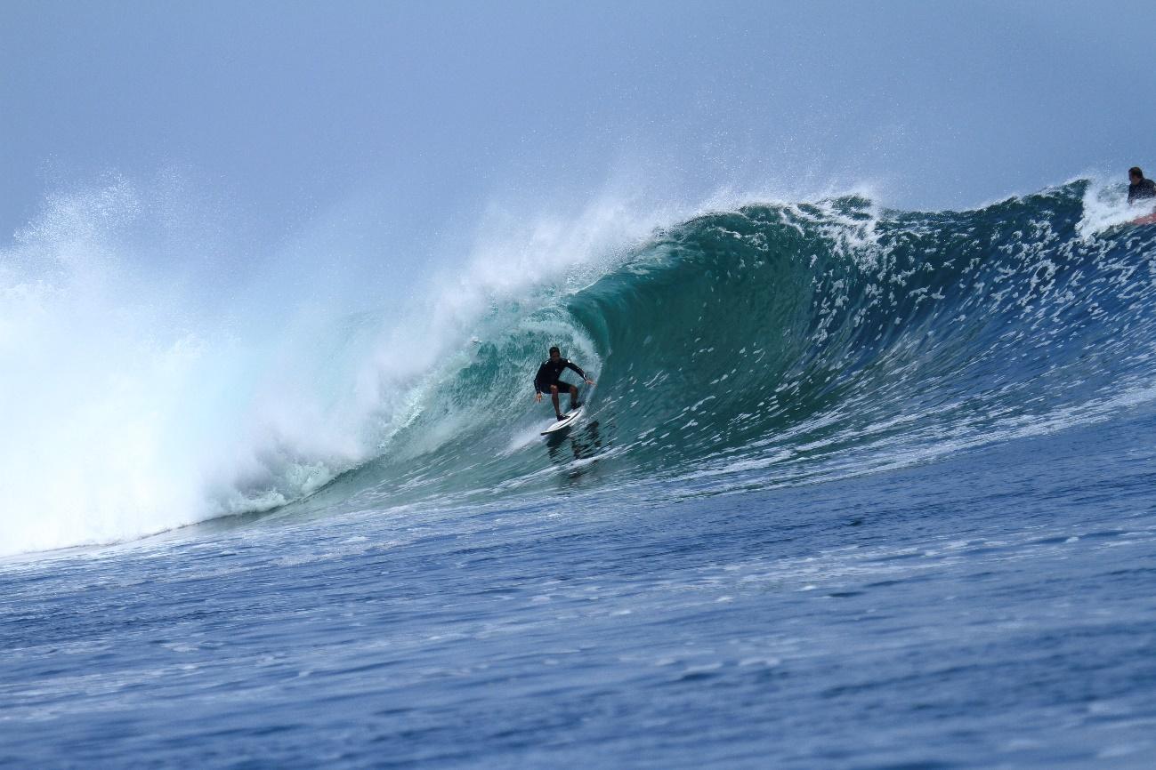 Homem surfando uma onda no mar    Descrição gerada automaticamente