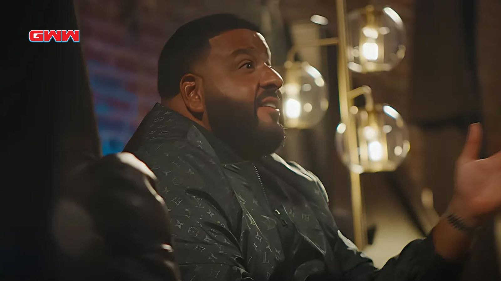 DJ Khaled animatedly speaking in a well-lit bar setting