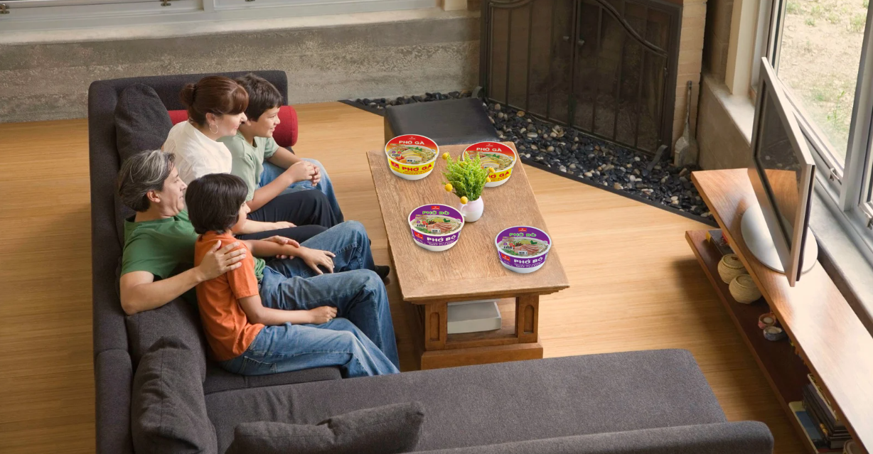 (familie kijkt tv terwijl ze pho eet)